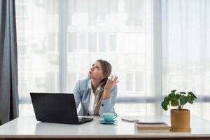 Noise Pollution in an office, woman sat at laptop complaining about the noise